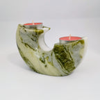 Marble-patterned candle holder with two red candles on a white background
