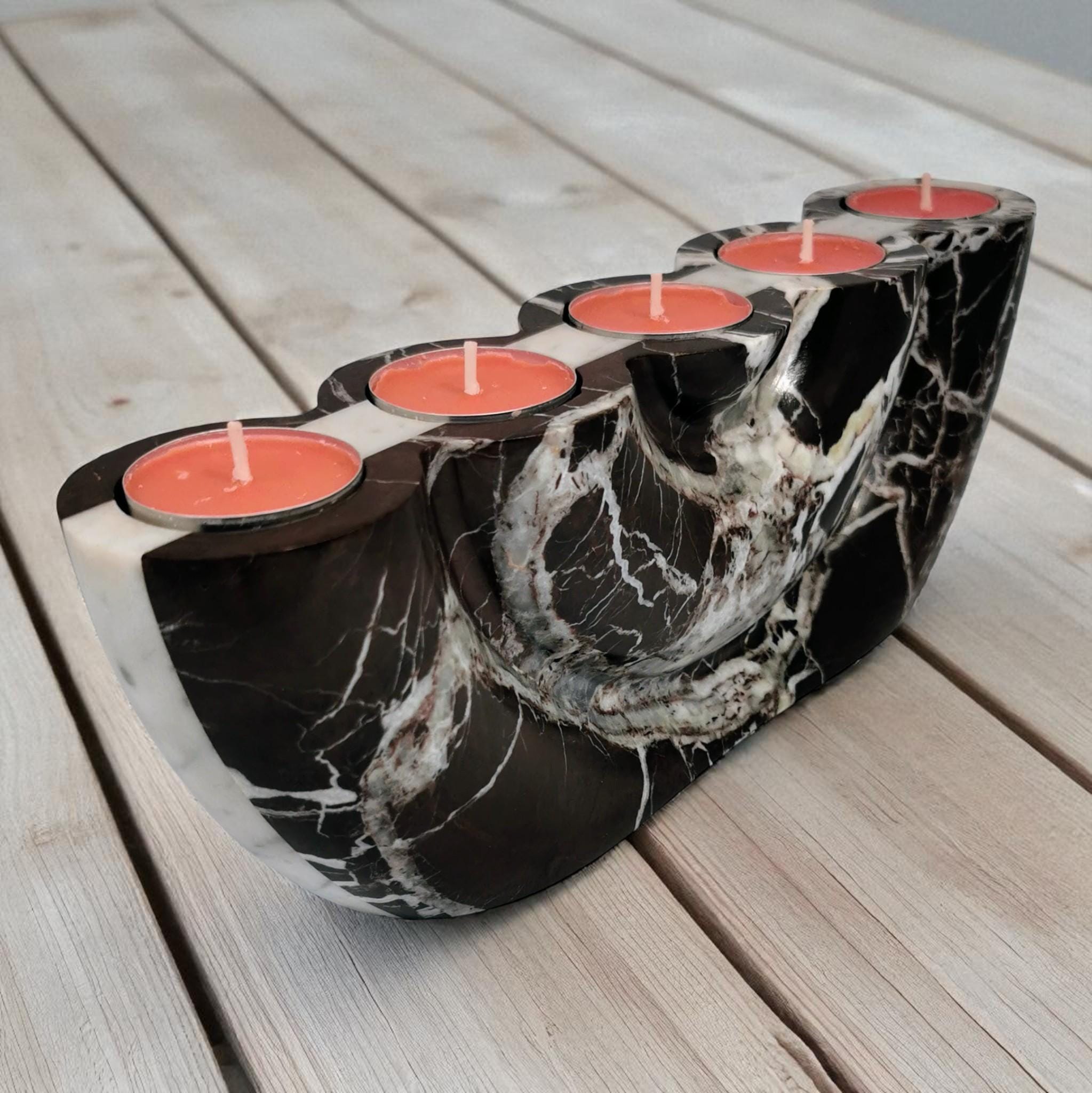 Marble-patterned candle holder with red candles on a wooden surface