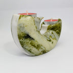 Marble-patterned candle holder with two candles on a light gray background