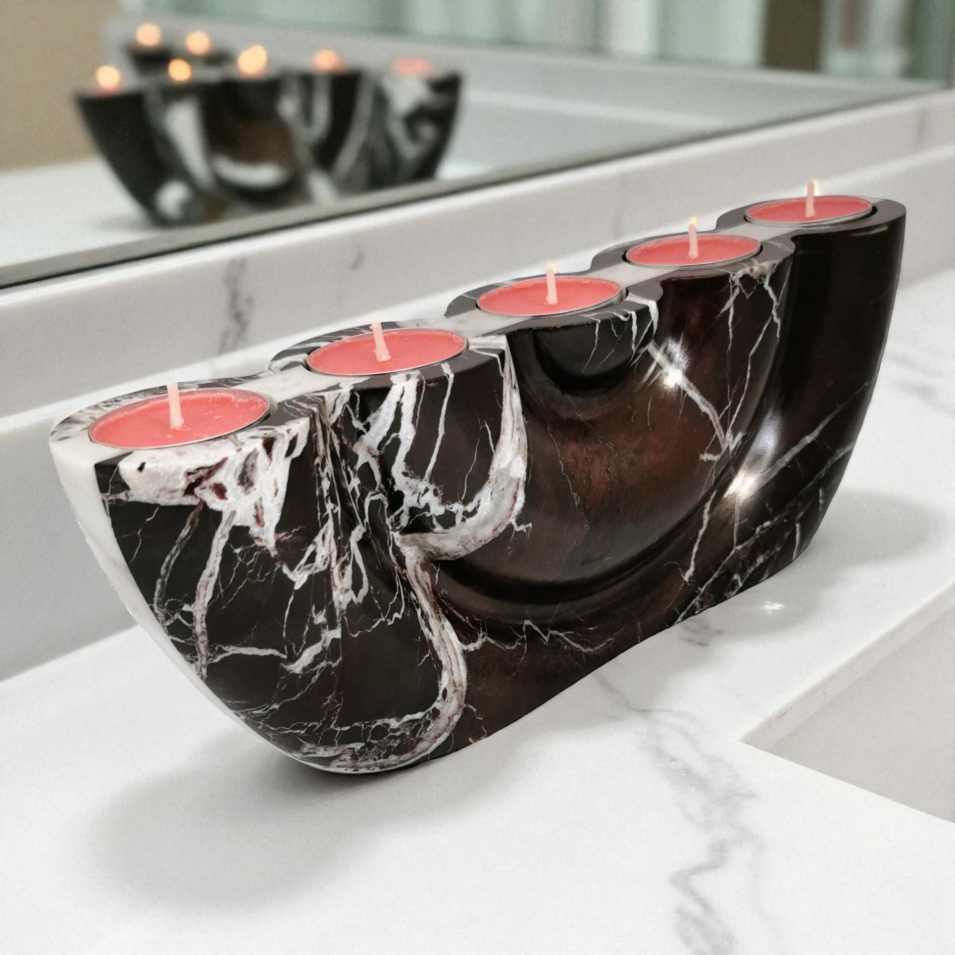 Marble-patterned candle holder with red candles on a white surface