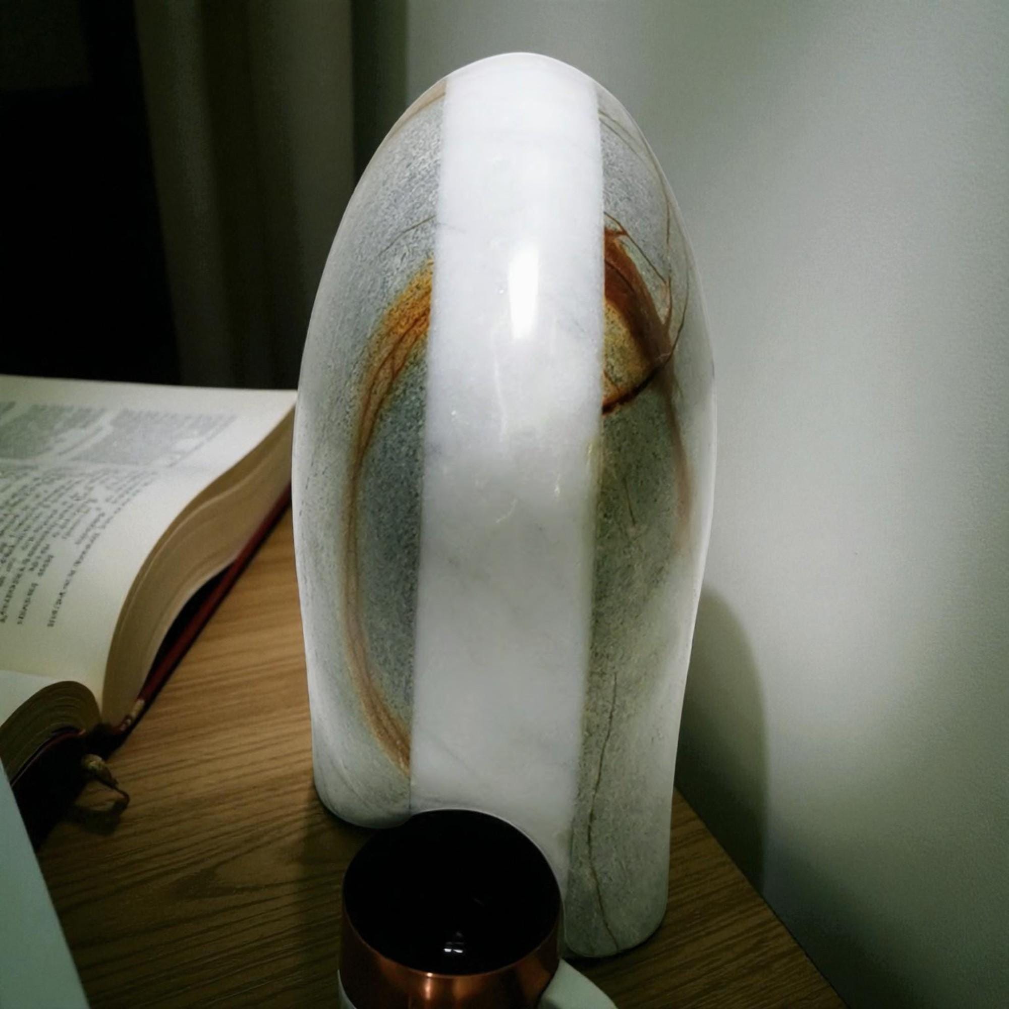 Marble-patterned lamp on a table next to an open book