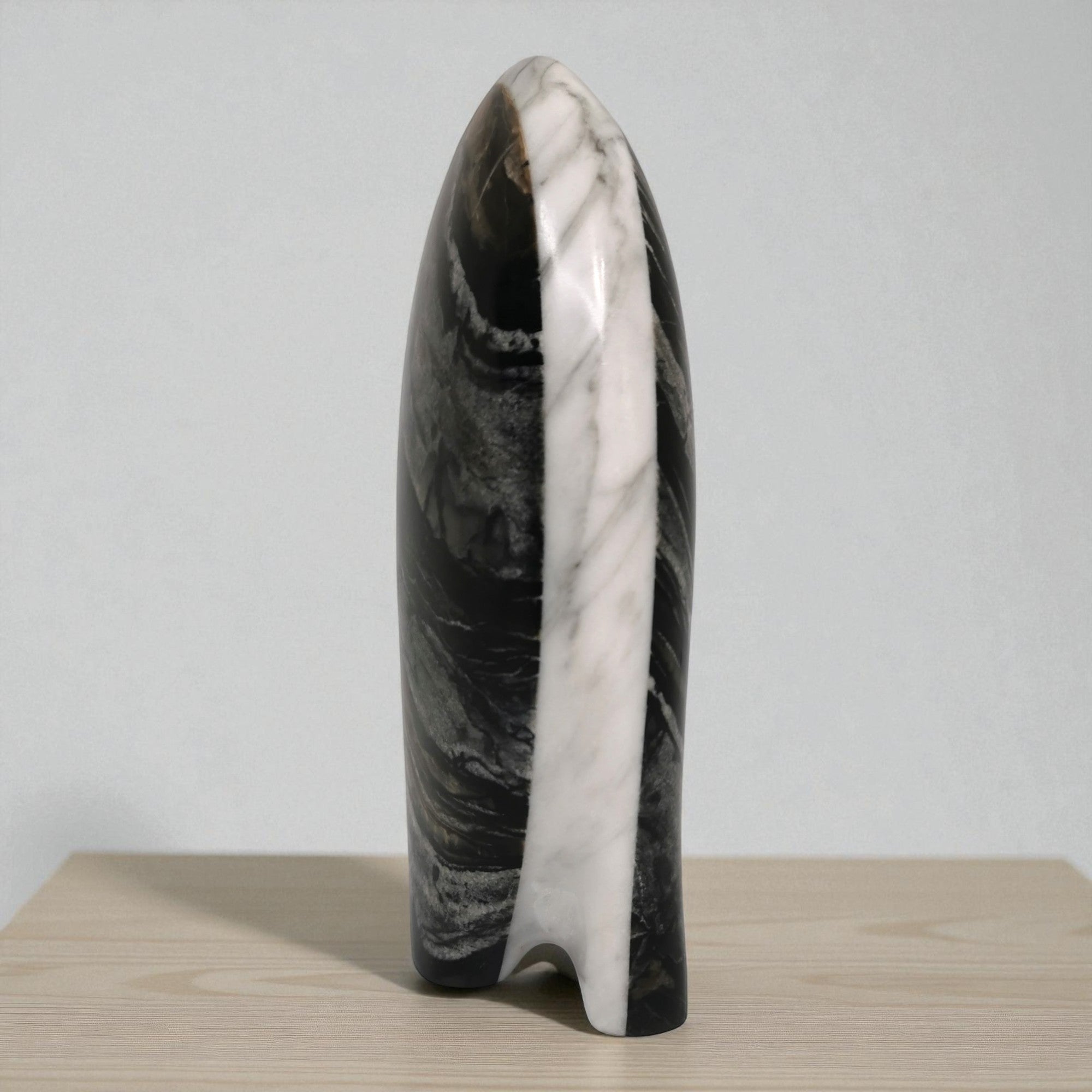 Marble-patterned vase on a wooden surface with a light gray background