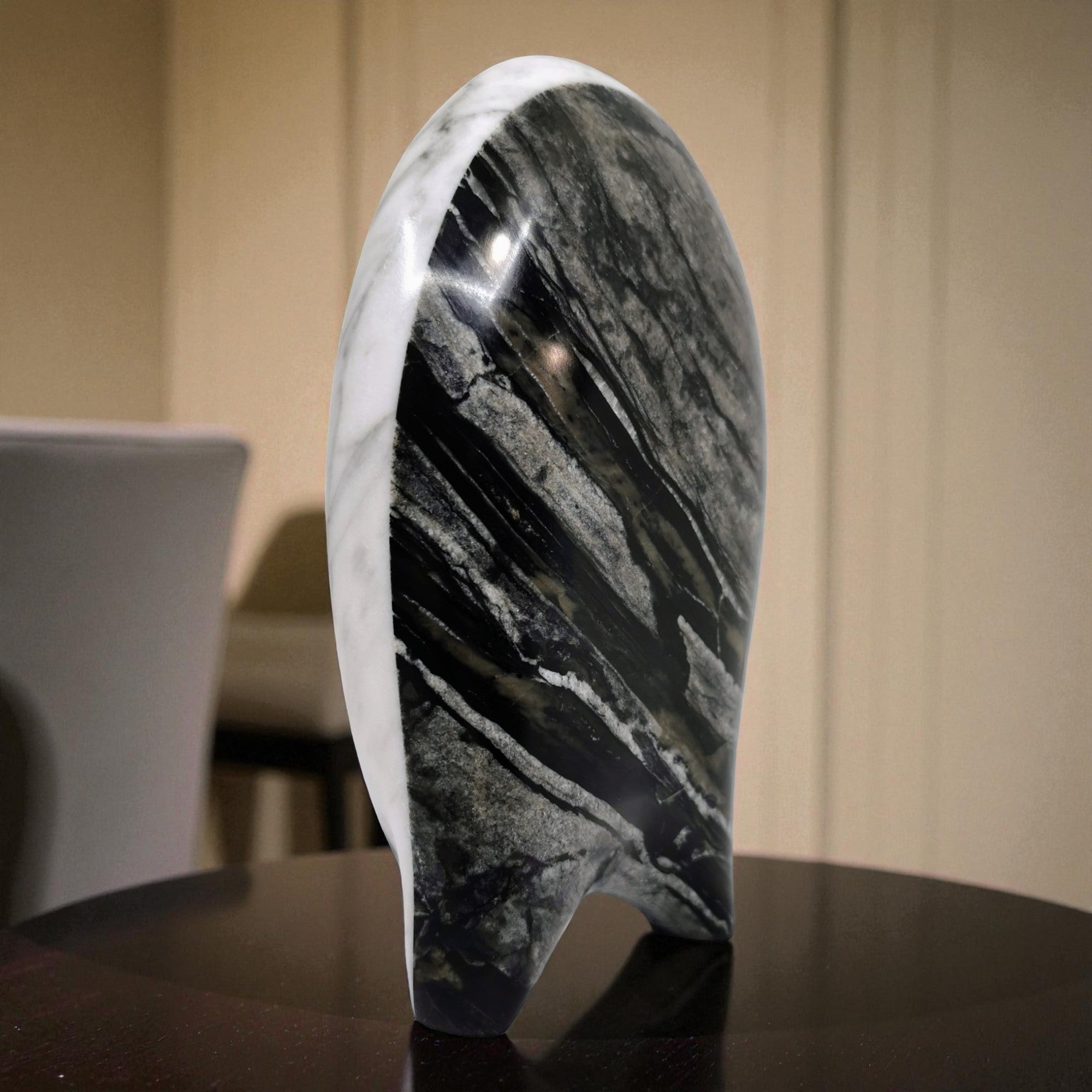 Marble-patterned object on a dark surface with a blurred background