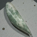 Green stone tool on a speckled gray surface