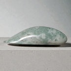 Green stone on a gray surface with a neutral background