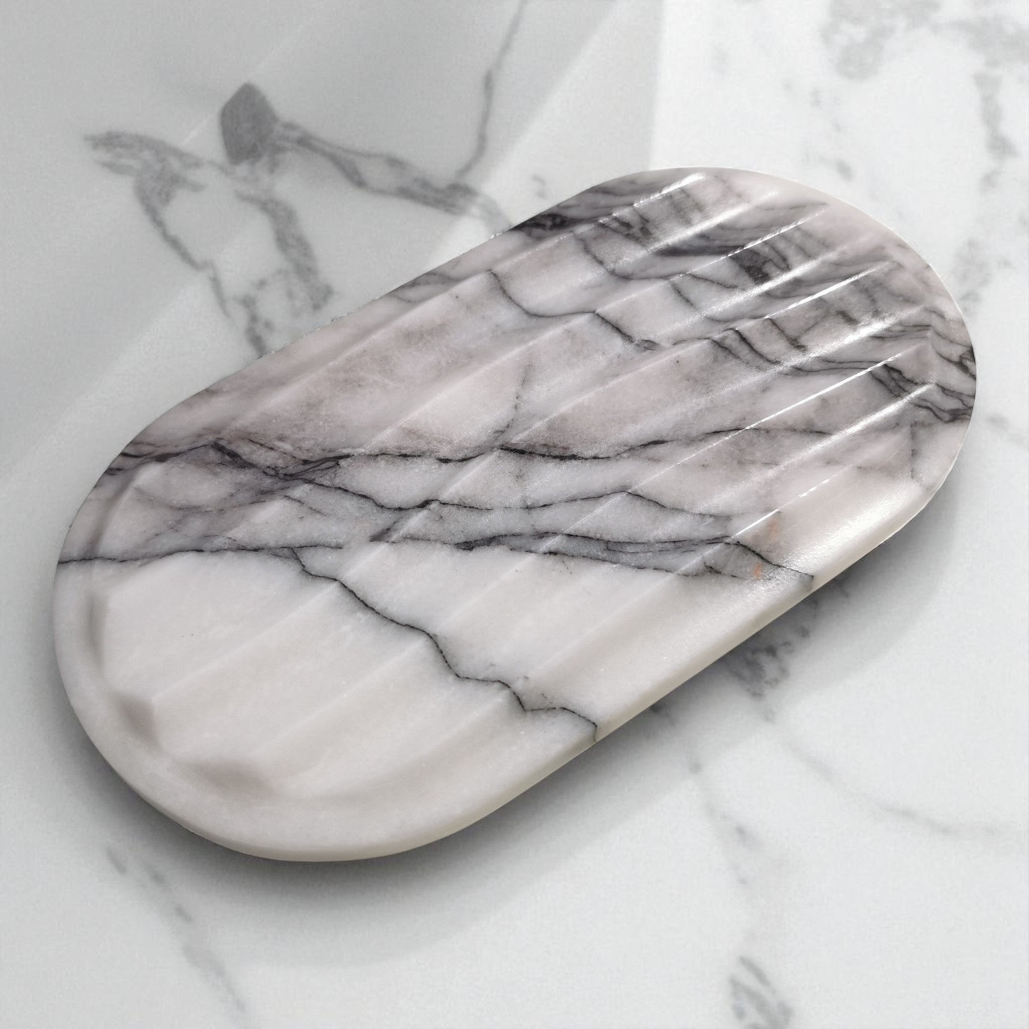 Marble-patterned oval serving tray on a marble surface