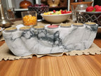 Marble-patterned candle holder with candles on a wooden table.