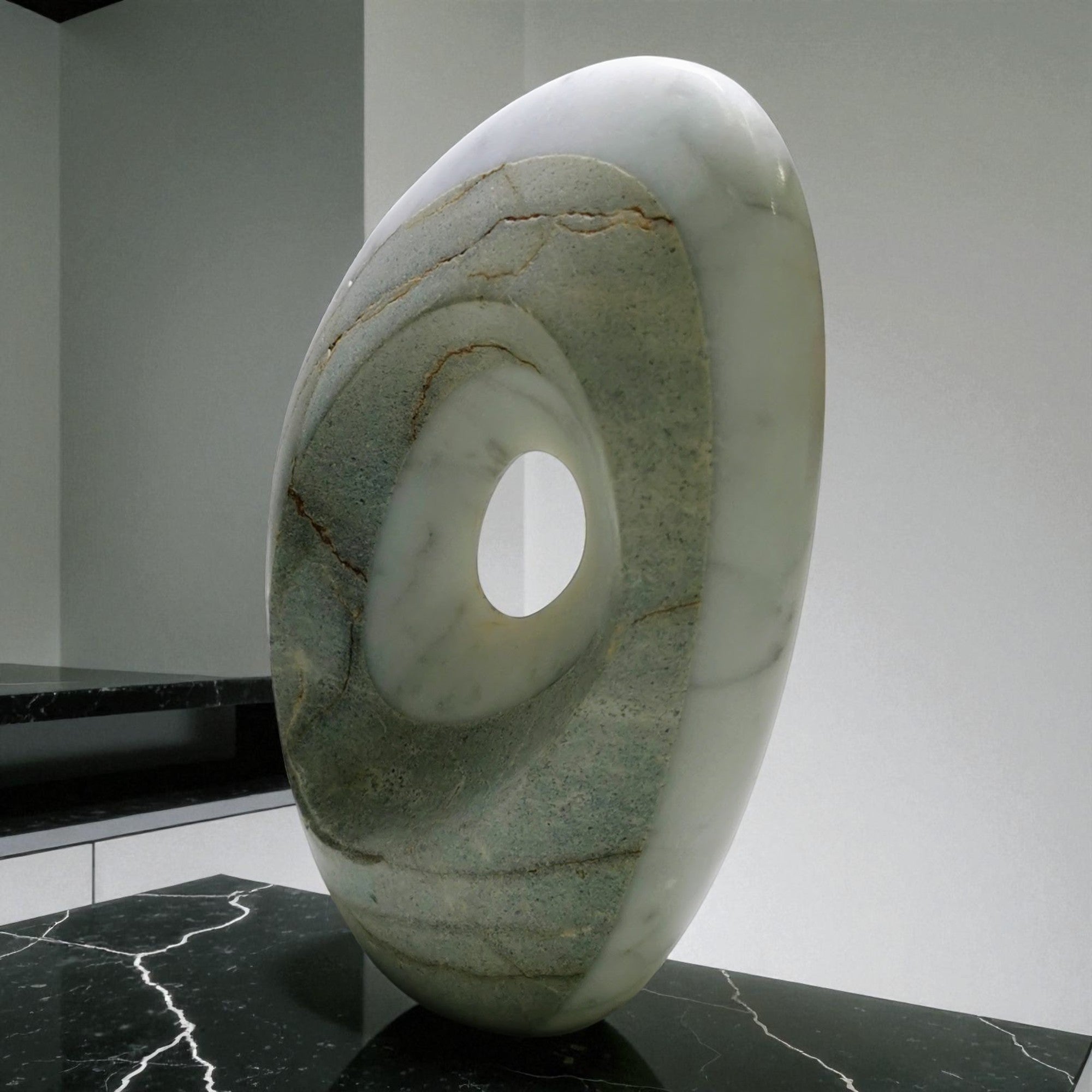 Marble sculpture with a central hole on a dark surface