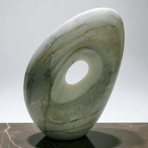 Continuum Void abstract marble sculpture, green-grey stone with white and rust veining and a central oval void, front view on a light background