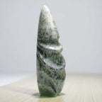 Green stone sculpture on a light gray background
