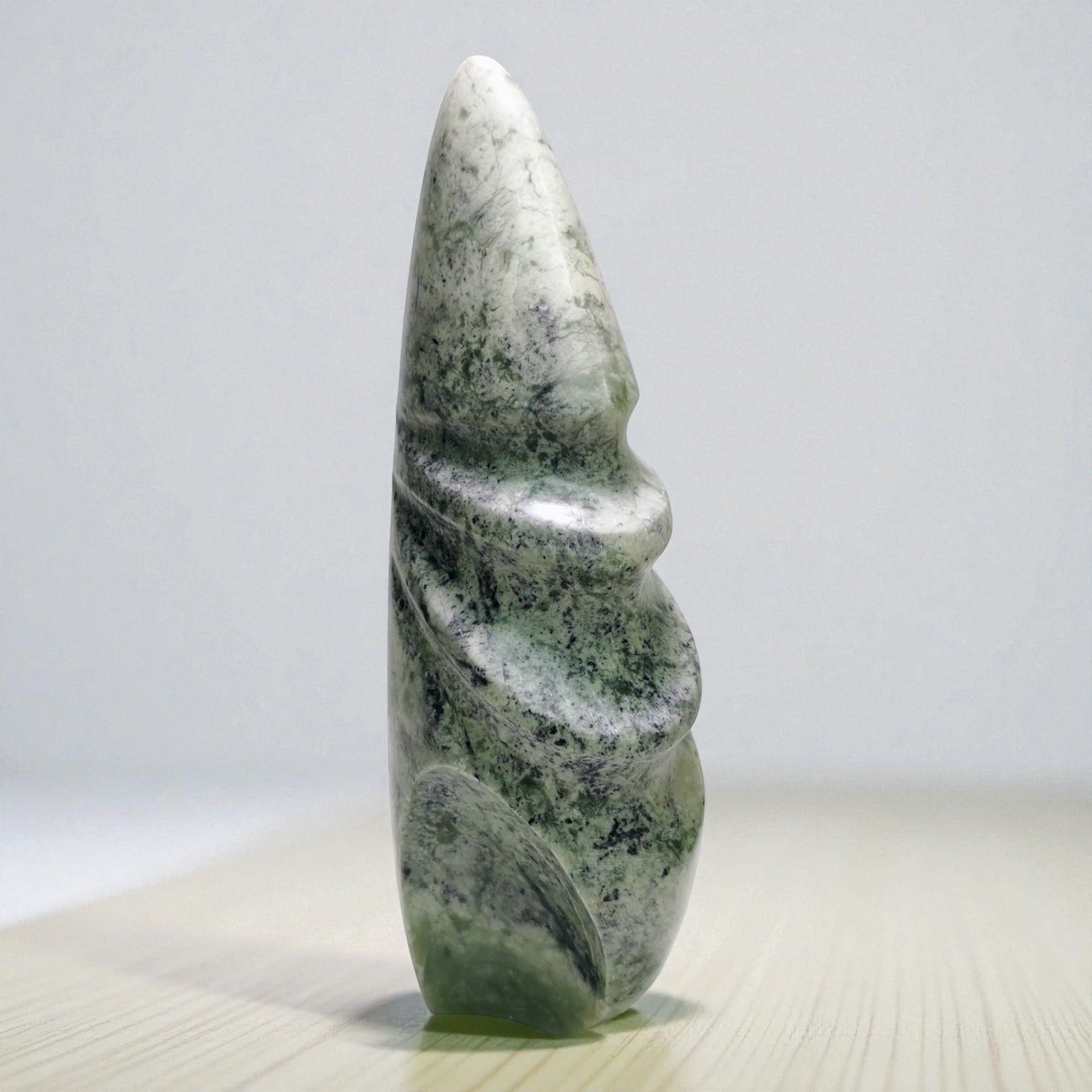 Green stone sculpture on a light gray background