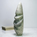 Stone sculpture of a figure on a white surface with a white background