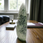 Decorative stone sculpture on a wooden table with a blurred indoor background