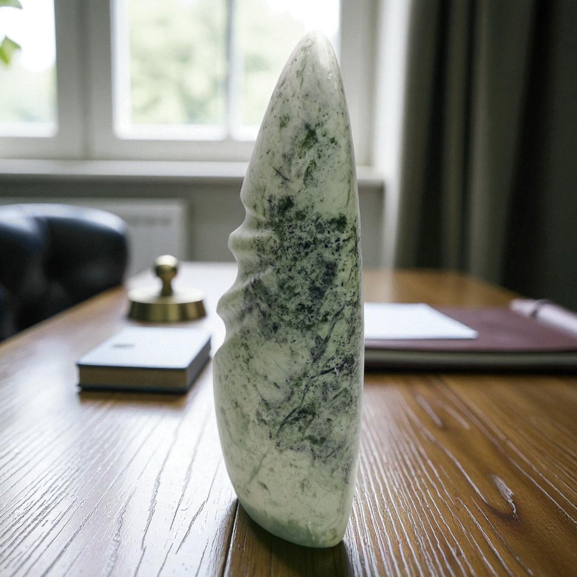 Decorative stone sculpture on a wooden table with a blurred indoor background