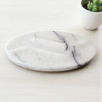 Marble-patterned plate on a light surface with a small plant in the background