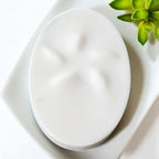 White ceramic plate on a white surface with a green plant in the corner