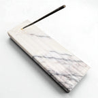 Marble-patterned incense holder with a single incense stick on a white background