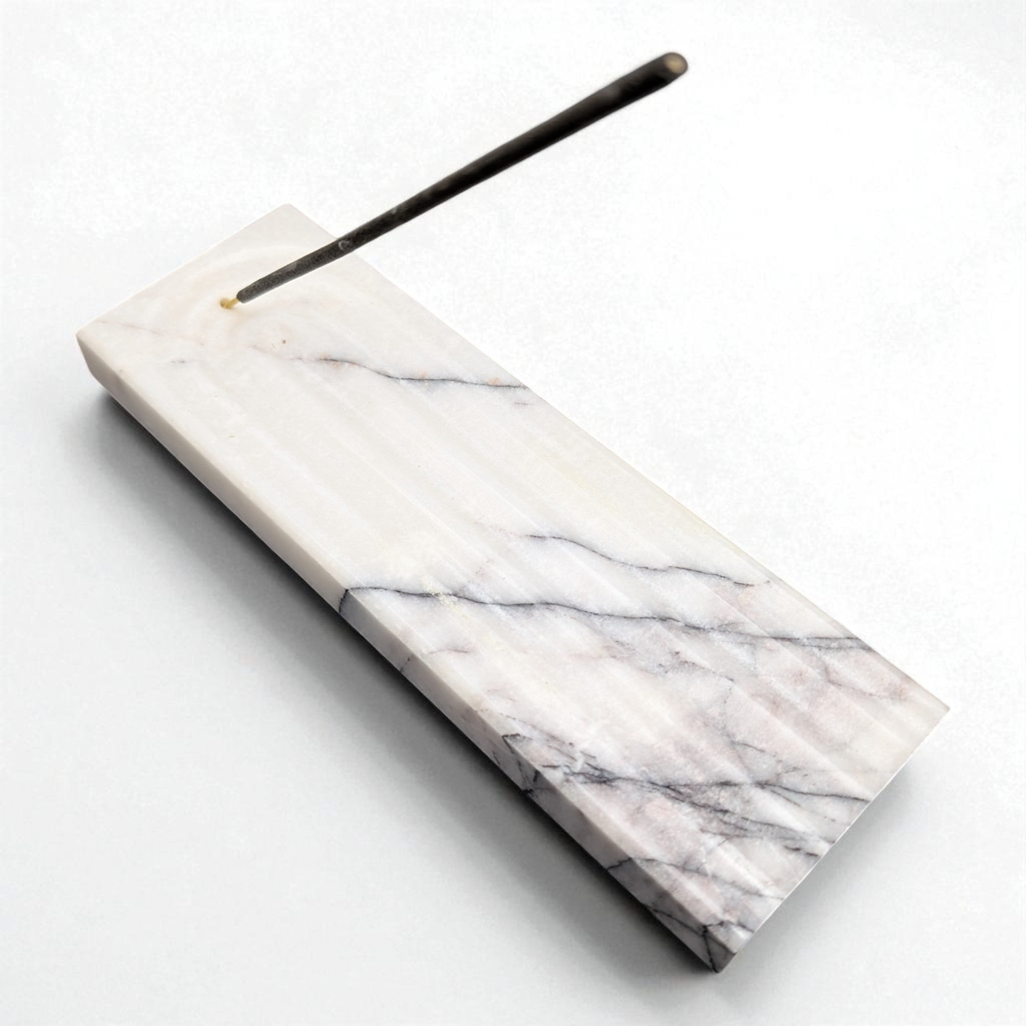Marble-patterned incense holder with a single incense stick on a white background
