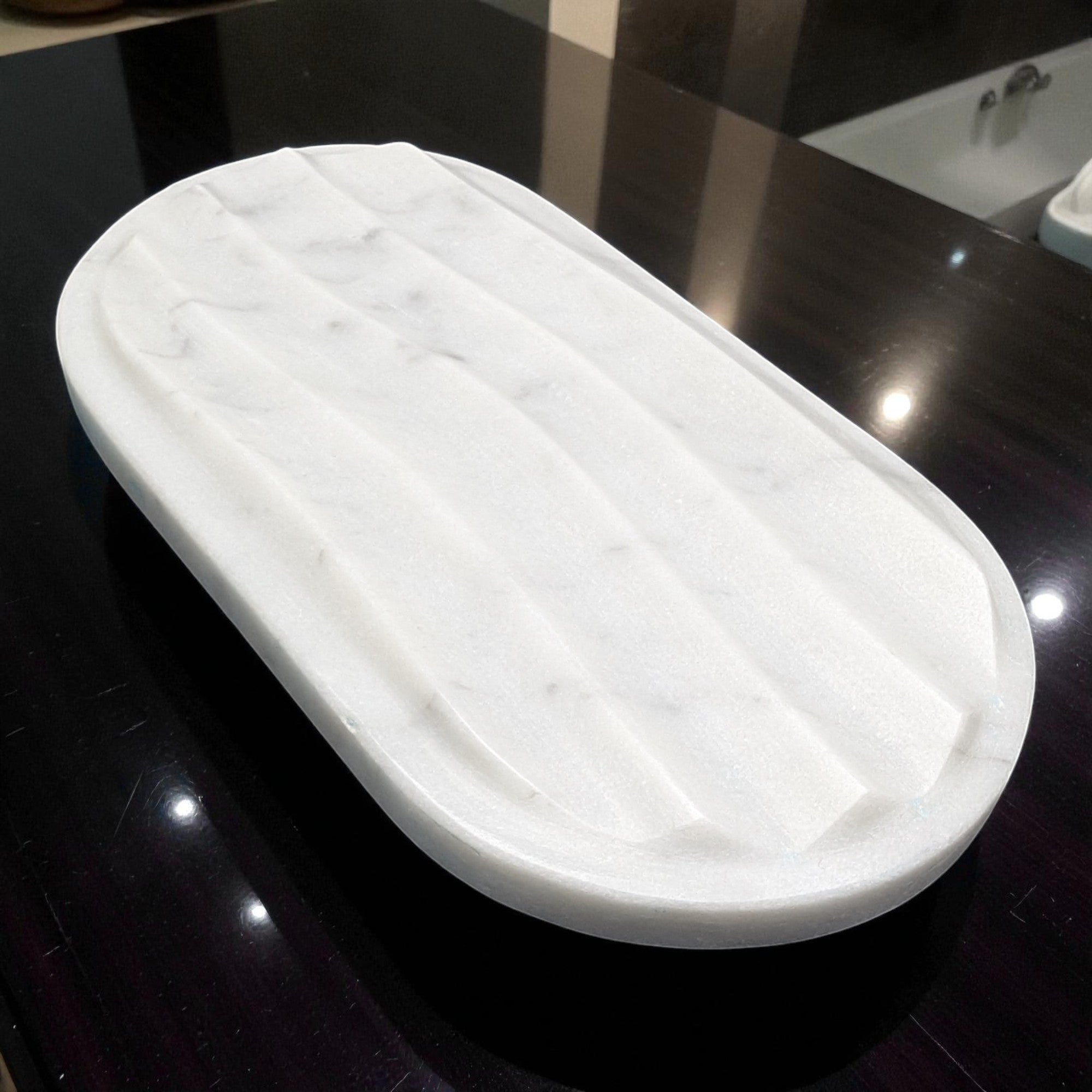 Marble-patterned soap dish on a dark surface