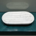 White marble tray on a teal surface with a gray background