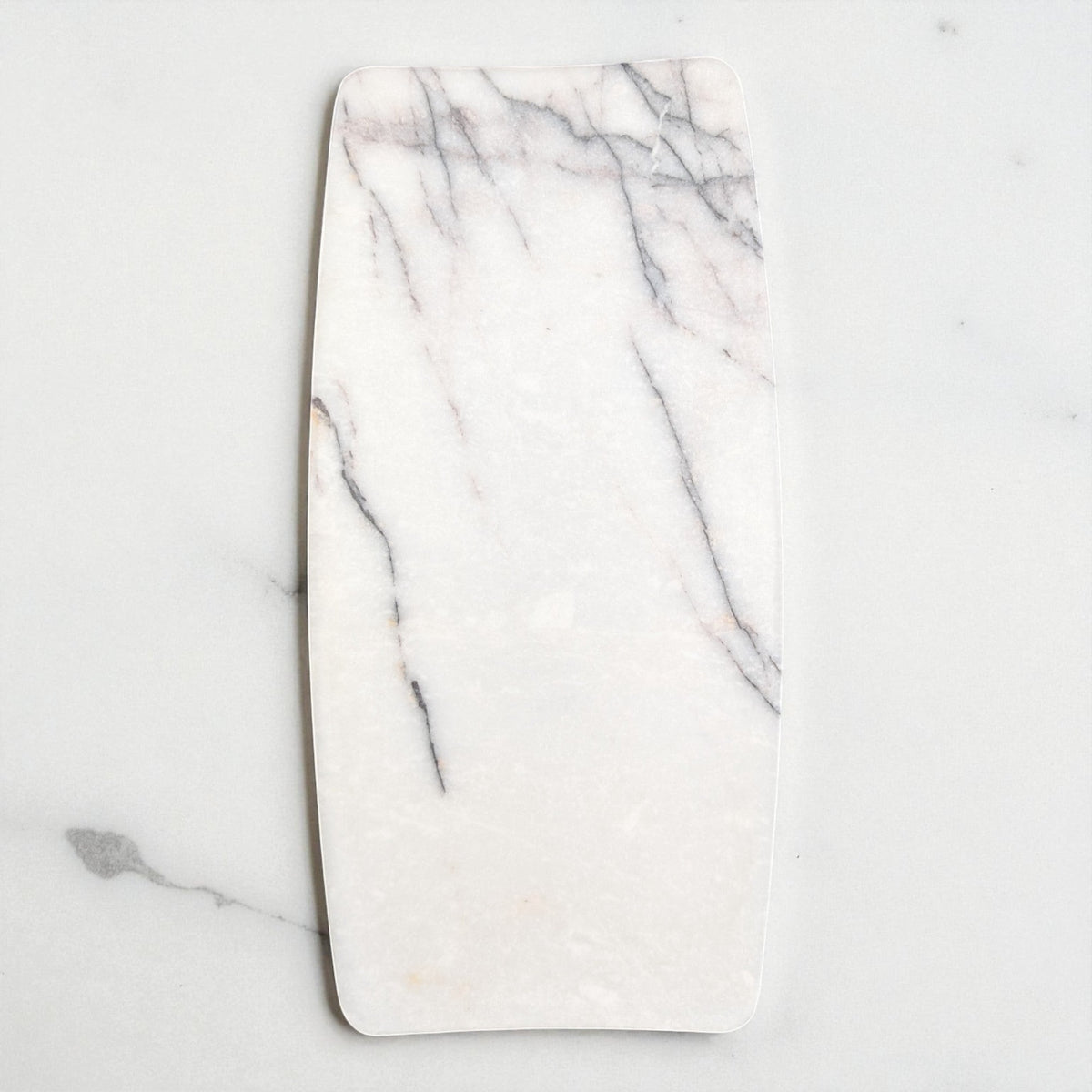 Oval marble jewelry tray from above, light grey background