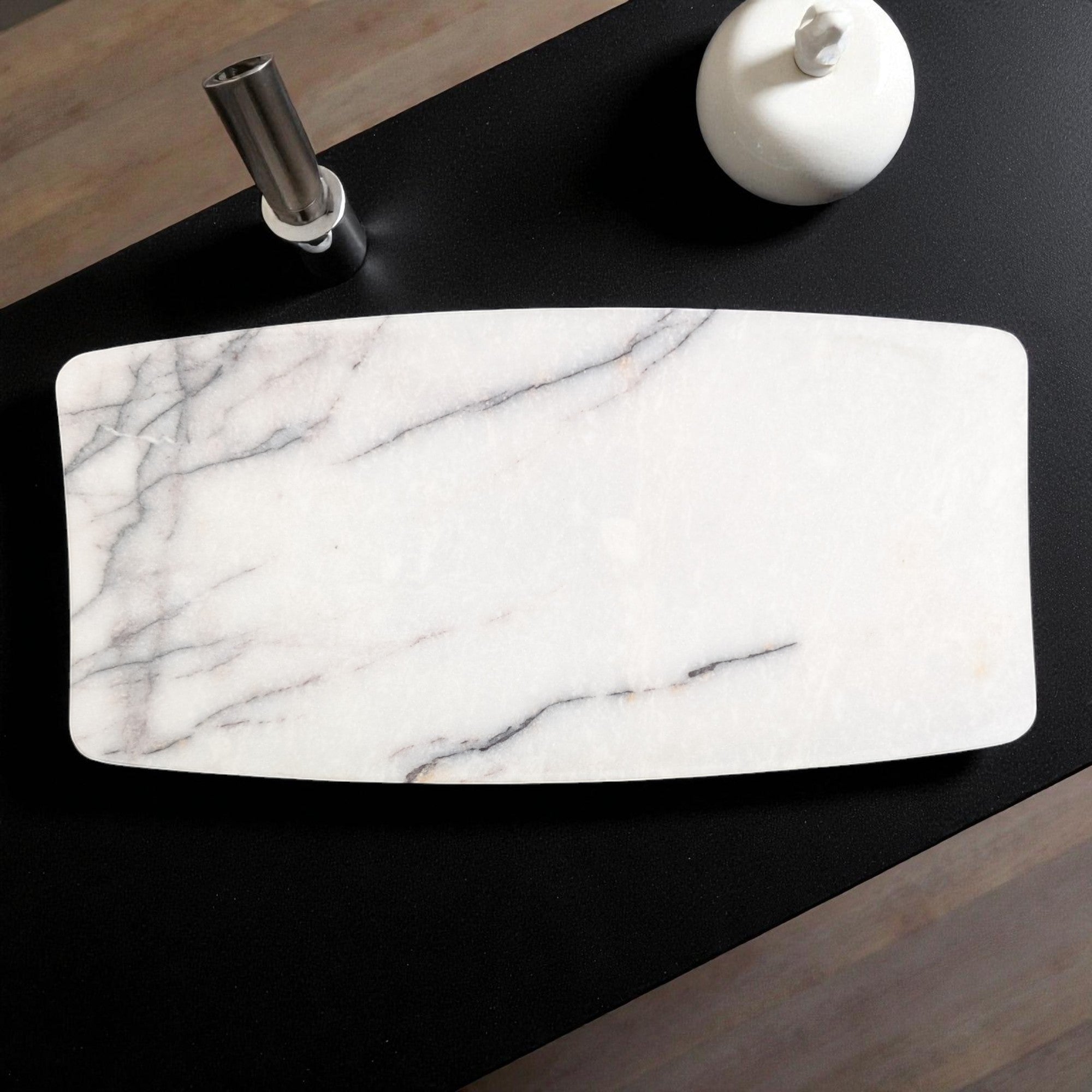 Marble-patterned tray on a black surface with a white ceramic item.