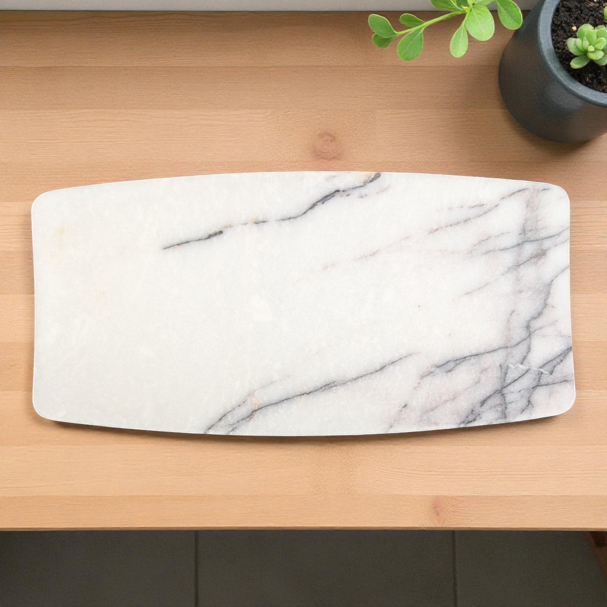 On a wooden surface with a plant in the background