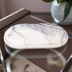 Marble-patterned stone on a reflective surface with a blurred background