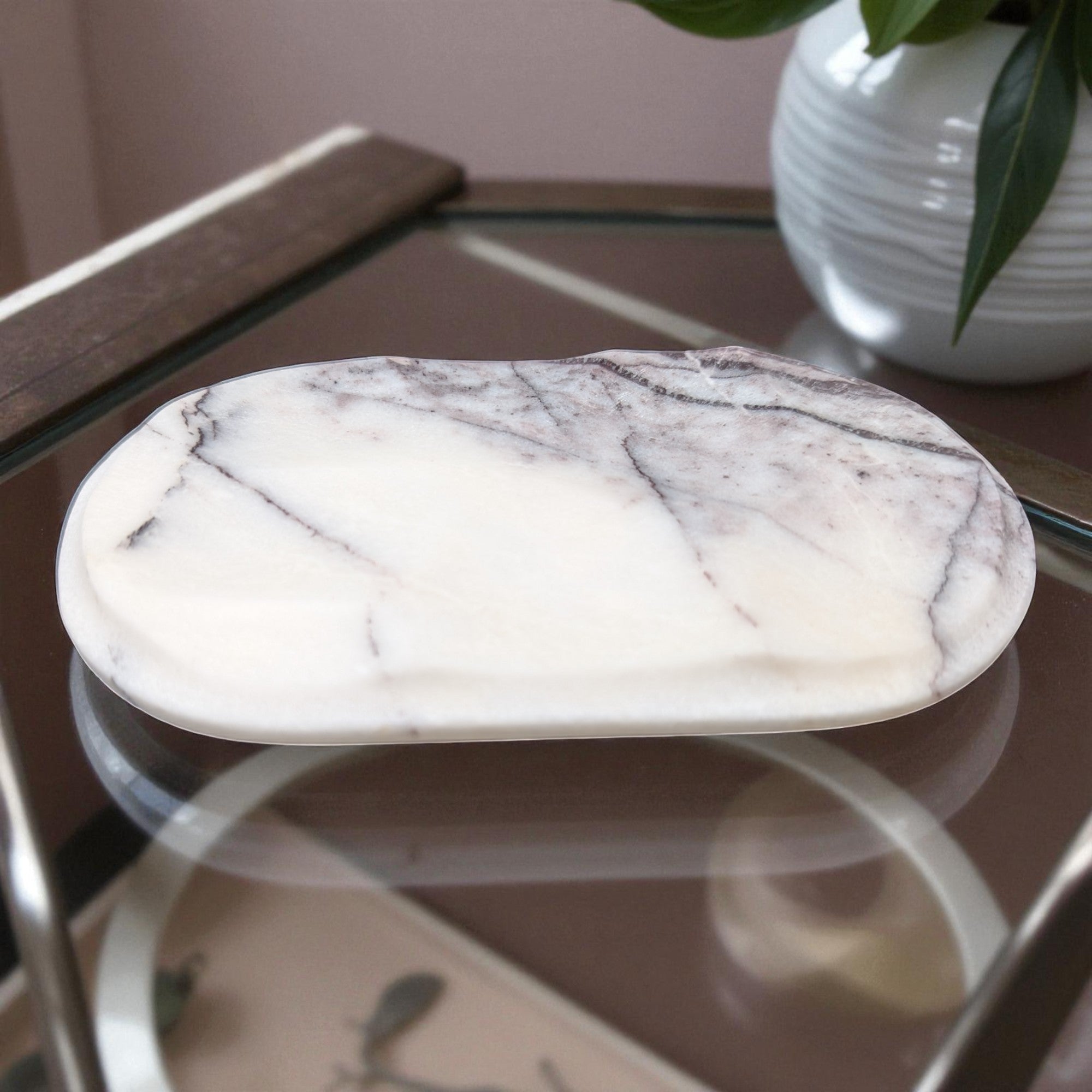 Marble-patterned stone on a reflective surface with a blurred background