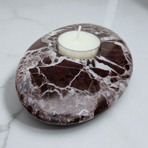 Marble-patterned stone with a candle on a white marble surface