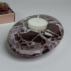 Marble-patterned stone with a candle inside on a light gray background