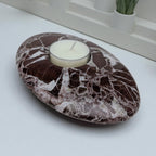 Marble-patterned stone with a candle on a white surface
