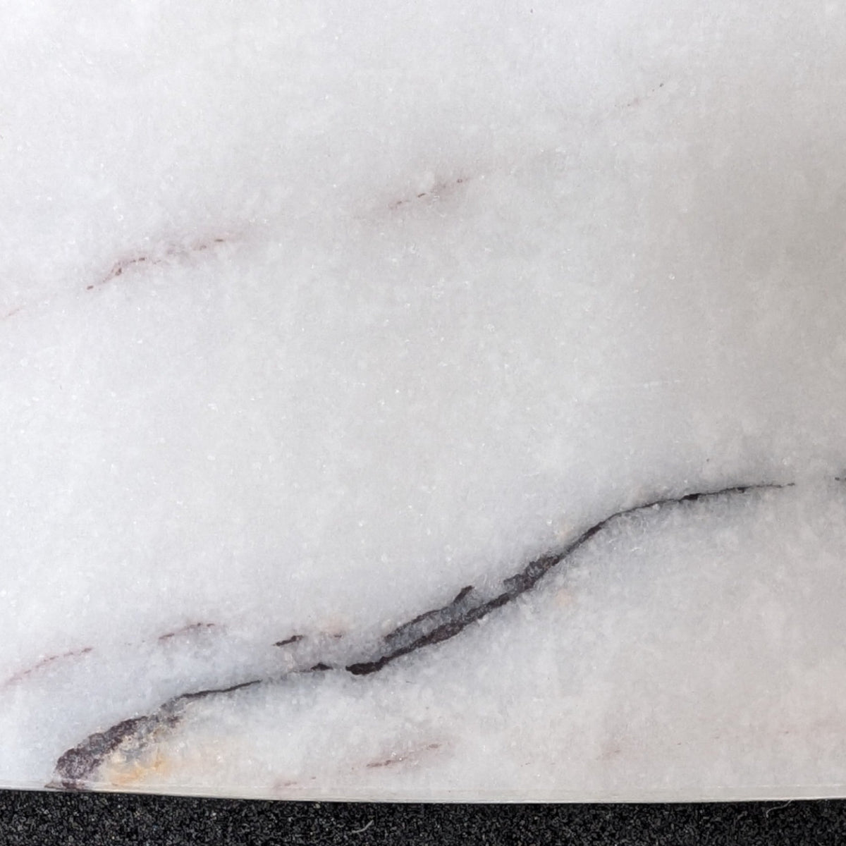 Close-up of the oval marble tray surface, grey and white veining