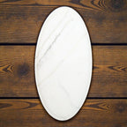 Oval-shaped marble cutting board on a wooden surface
