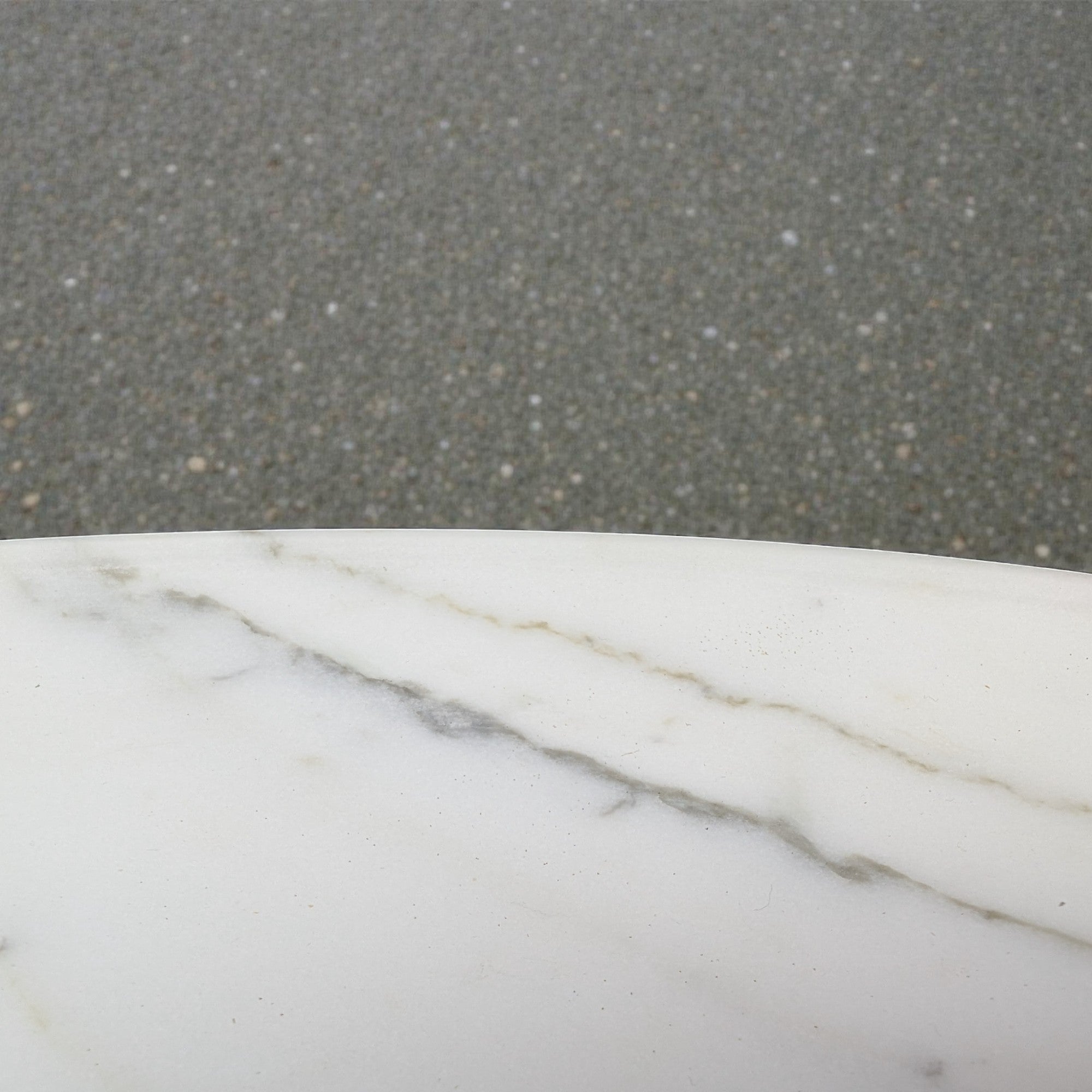 Close-up of a marble surface with a gray concrete background