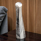 Marble-patterned vase on a wooden surface with a wooden panel background