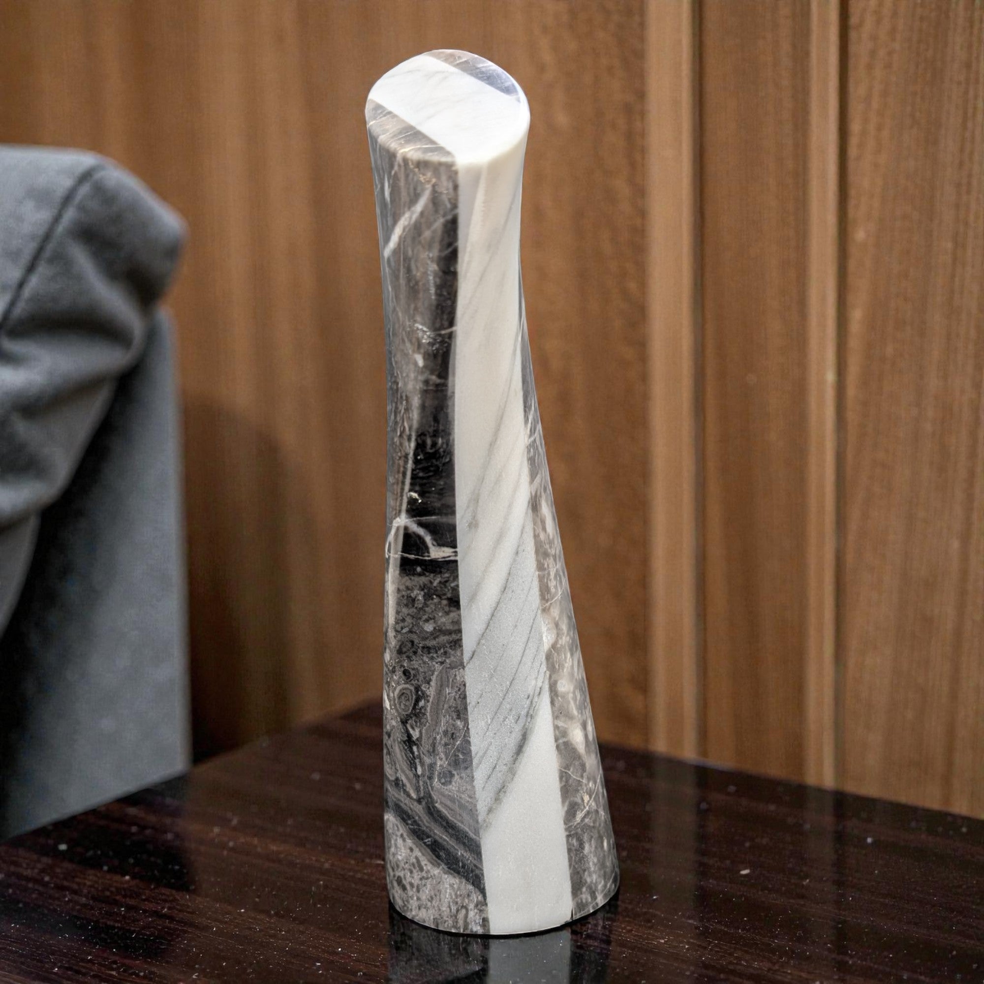 Marble-patterned vase on a wooden surface with a wooden panel background