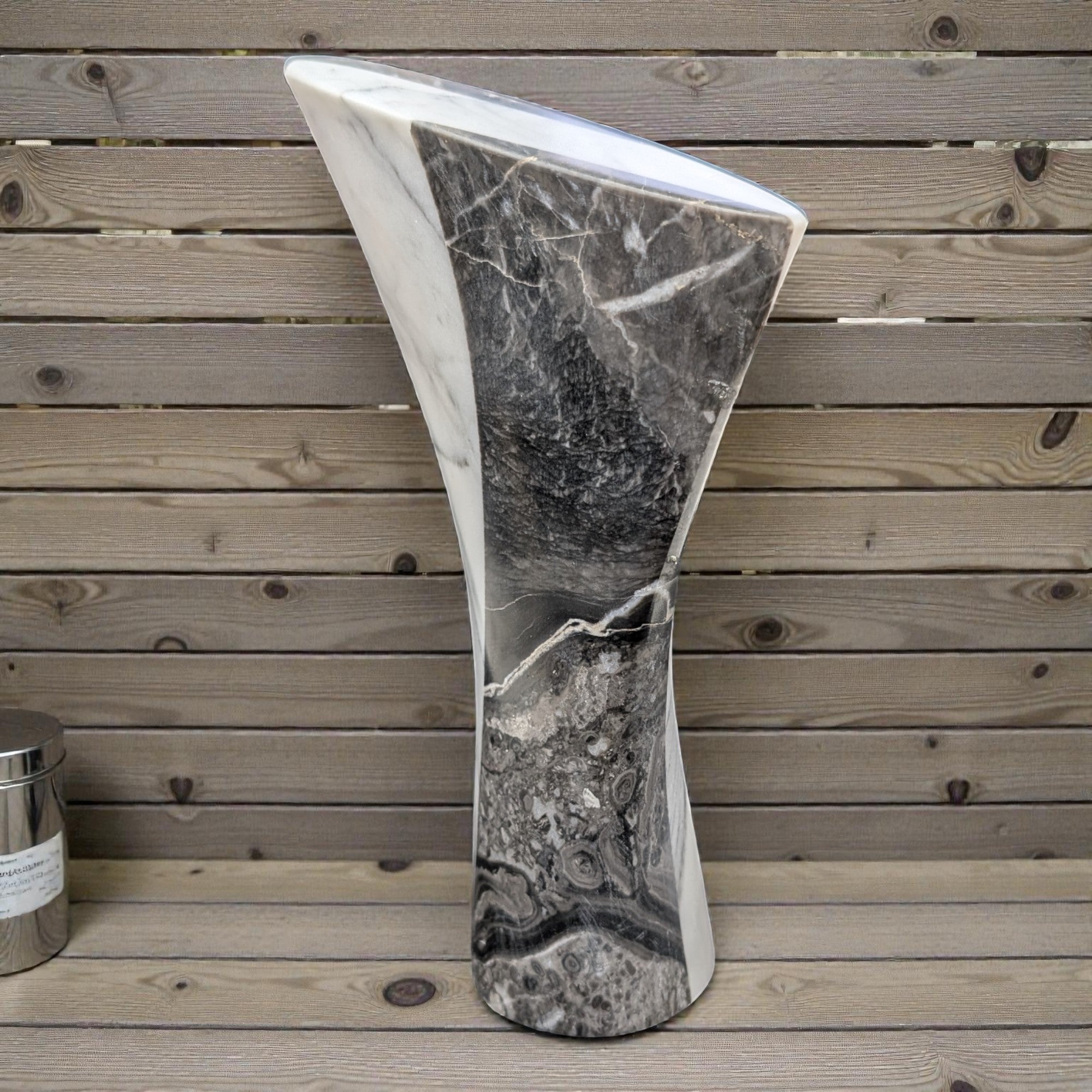 Marble-patterned freestanding bathtub against a wooden background
