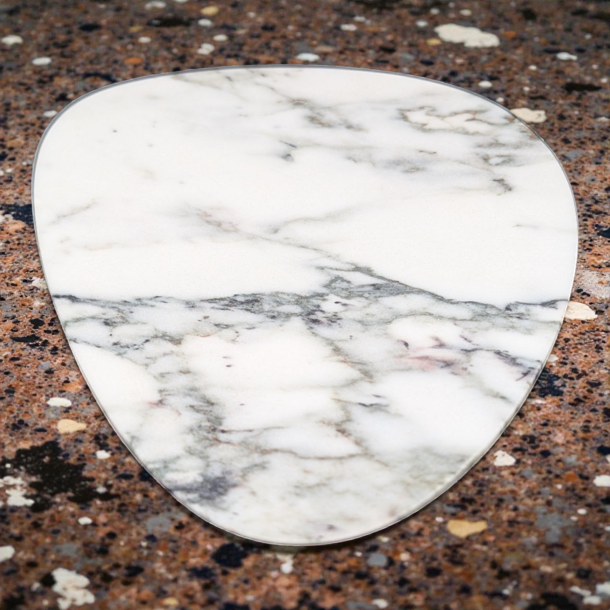 Marble-patterned guitar pick on a speckled surface