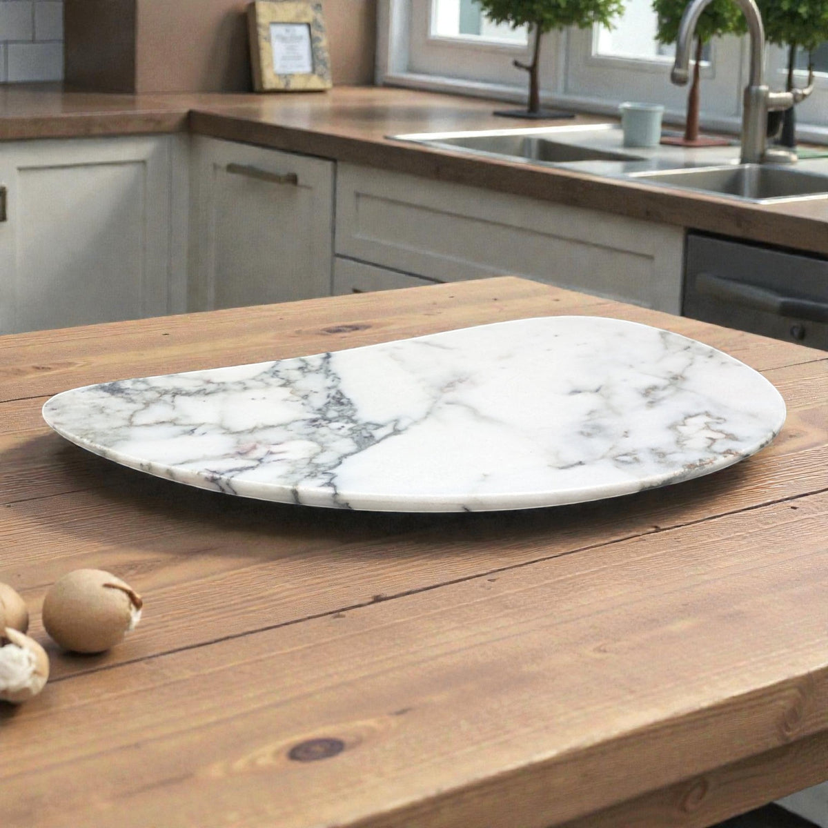 White marble jewelry tray, irregular shape, on a wooden kitchen table