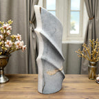 Decorative stone sculpture on a wooden surface with floral arrangements in the background