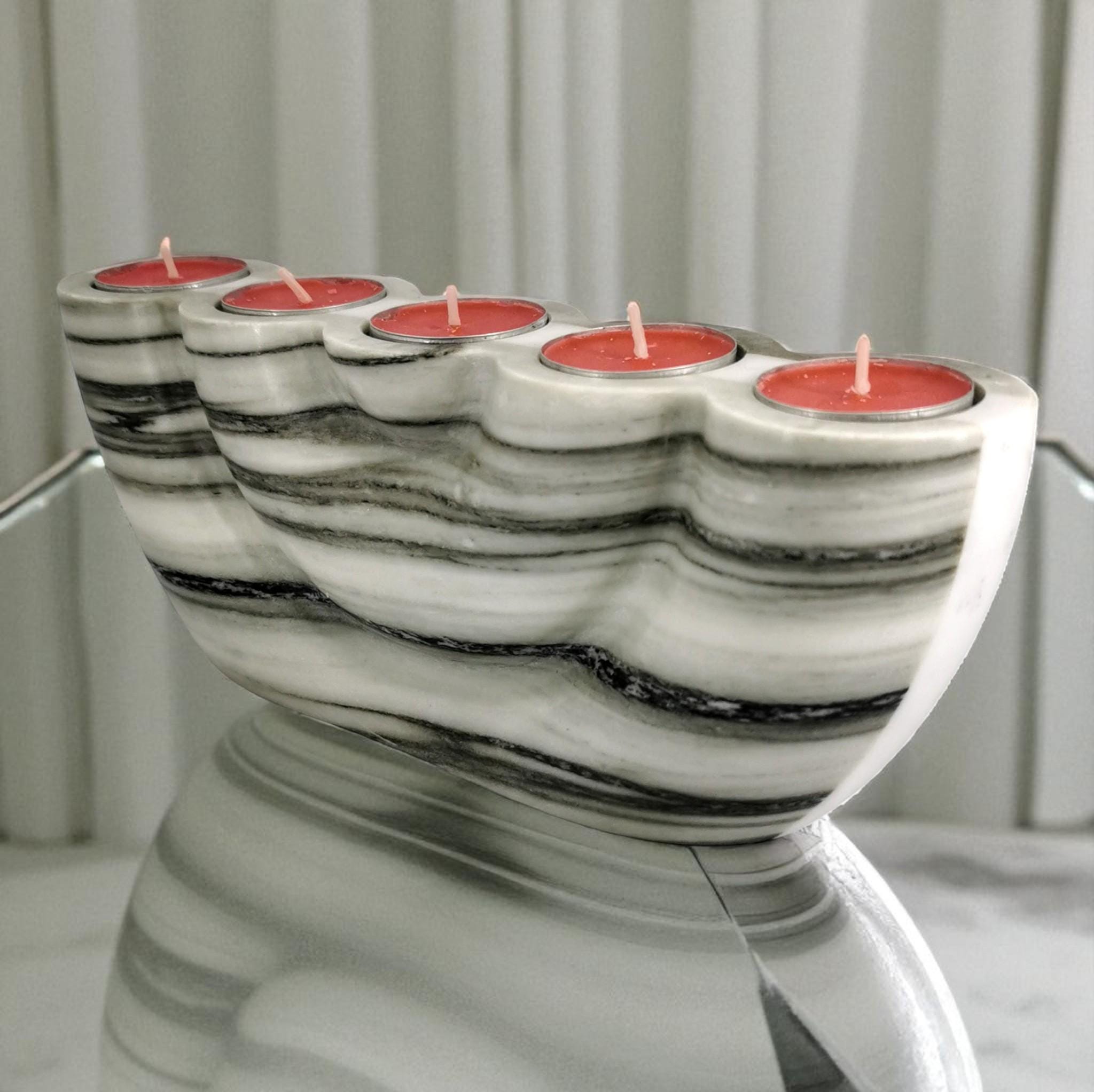 Marble-patterned candle holder with red candles on a neutral background