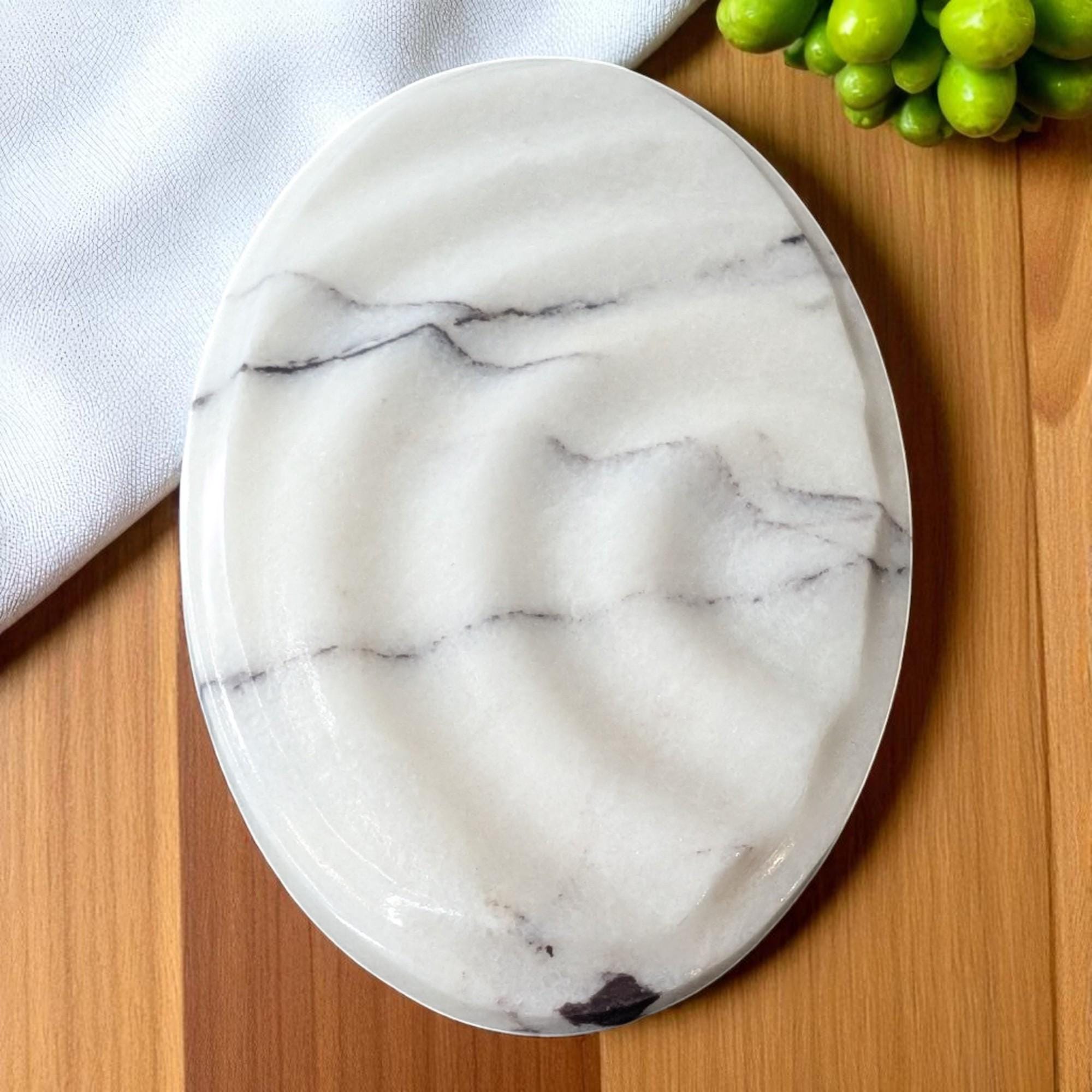 Marble-patterned plate on a wooden surface with a white cloth and green fruit in the background