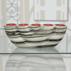 Marble-patterned candle holder with red candles on a glass surface