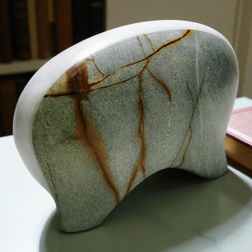 Hand-carved abstract marble sculpture with organic guardian form, light green stone
with natural brown veining, artisan-made luxury home decor piece