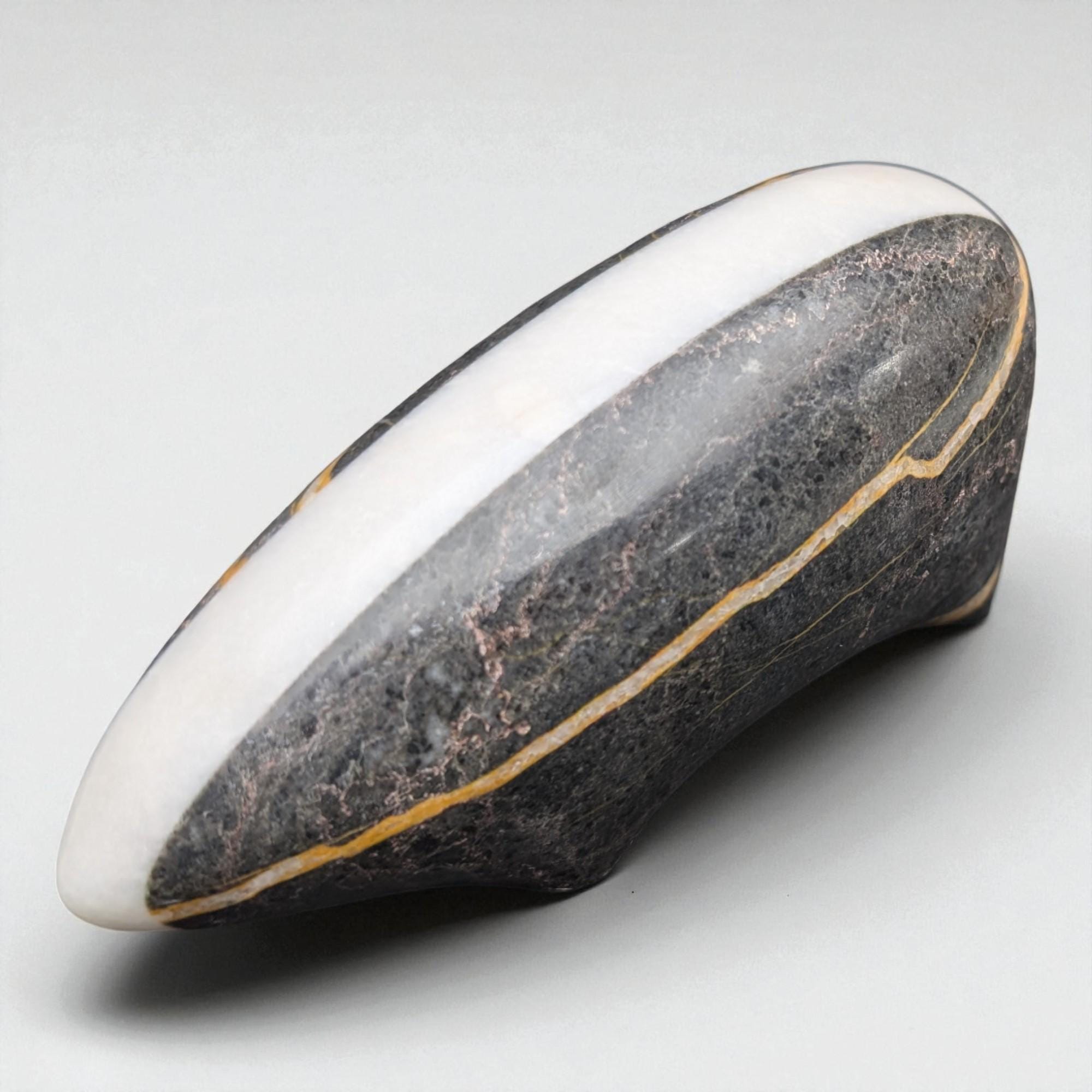 Black and white stone with a gold line on a gray background