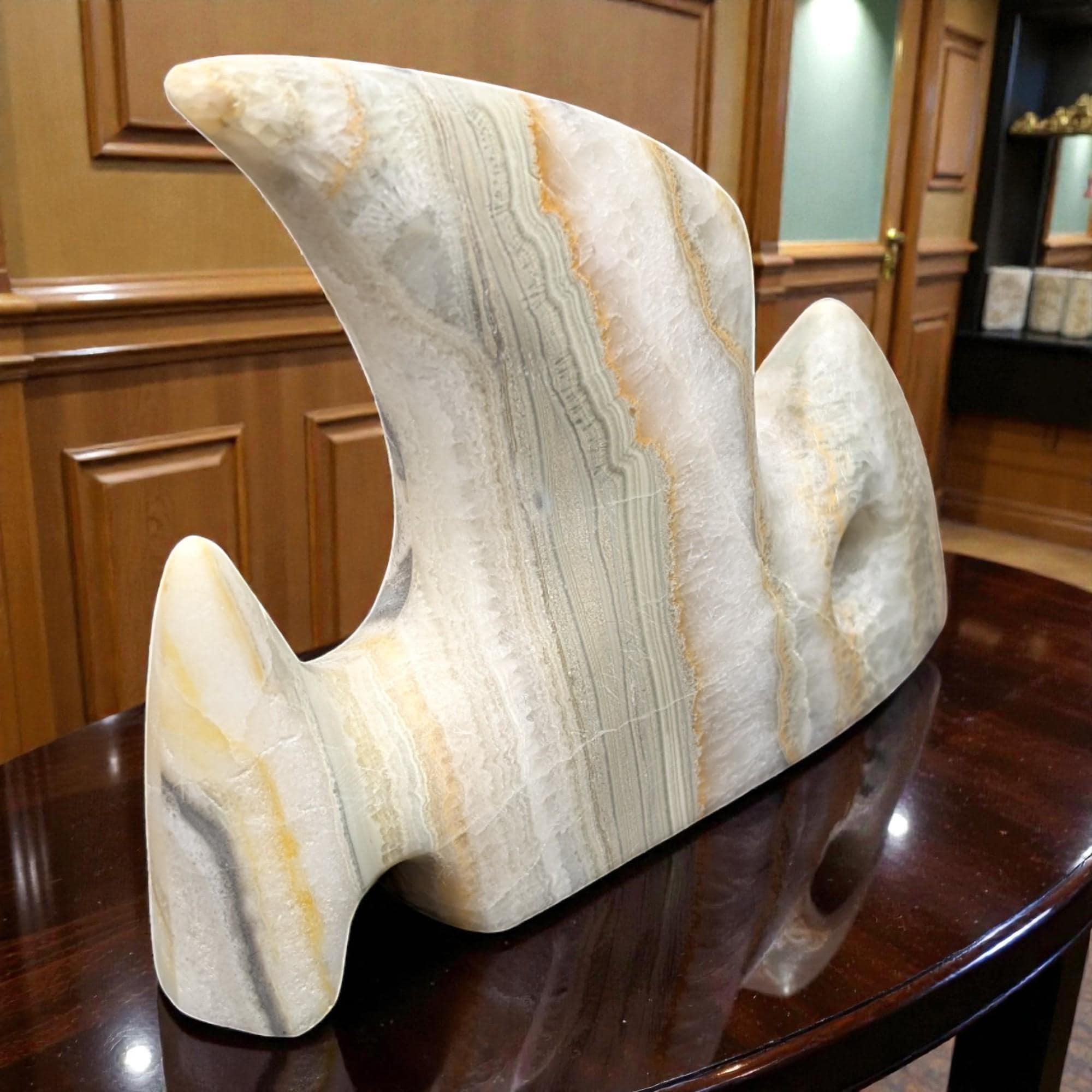 Marble sculpture on a wooden table with a wooden cabinet background