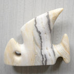 Marble-patterned fish-shaped object on a gray background
