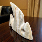 Decorative stone sculpture on a wooden surface with a blurred background