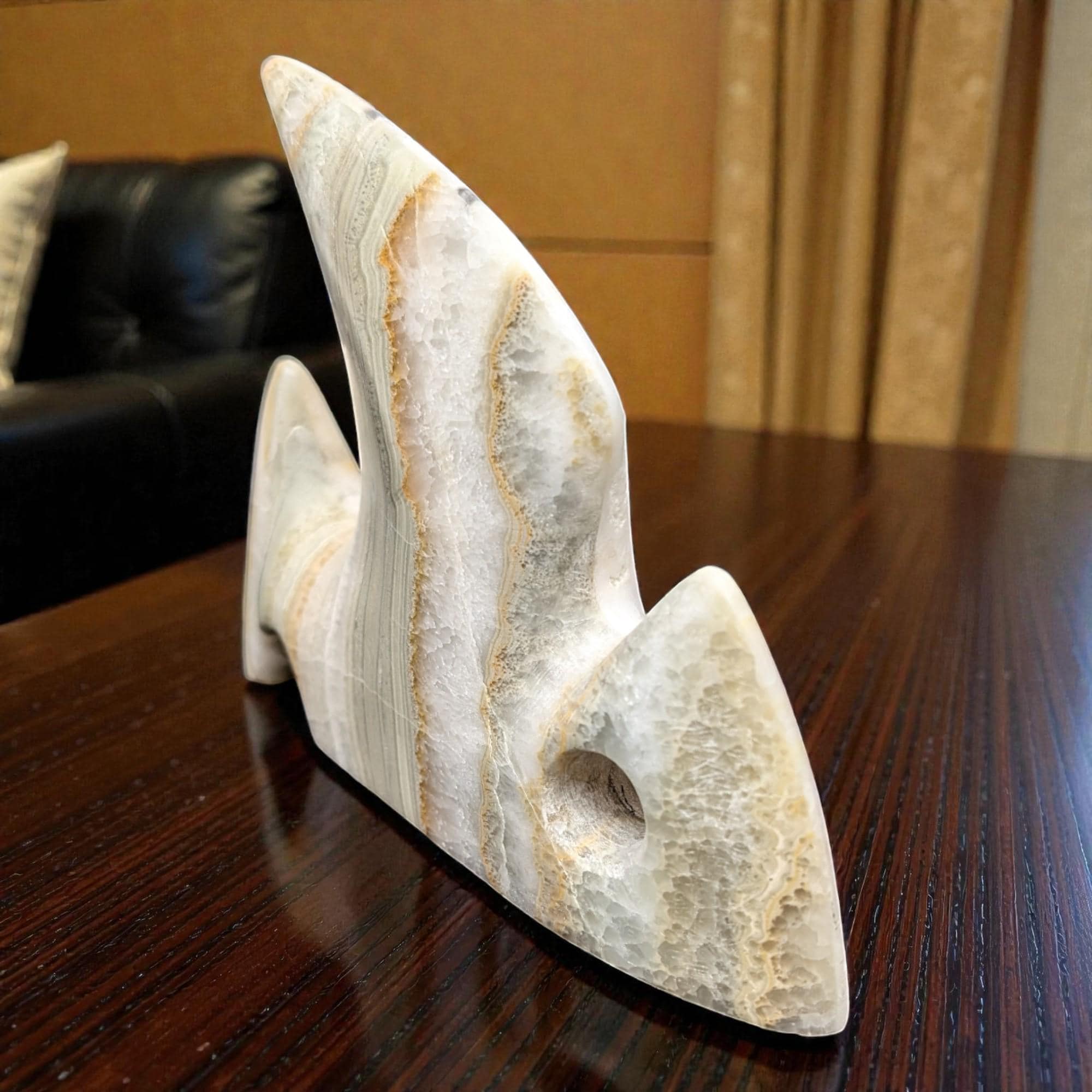 Decorative stone sculpture on a wooden surface with a blurred background